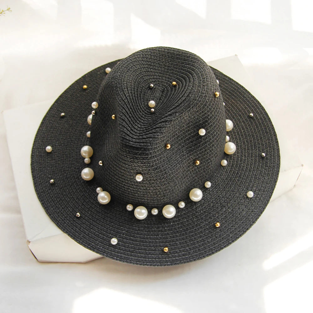 Elegant straw hat with pearl trim on display stand against neutral background