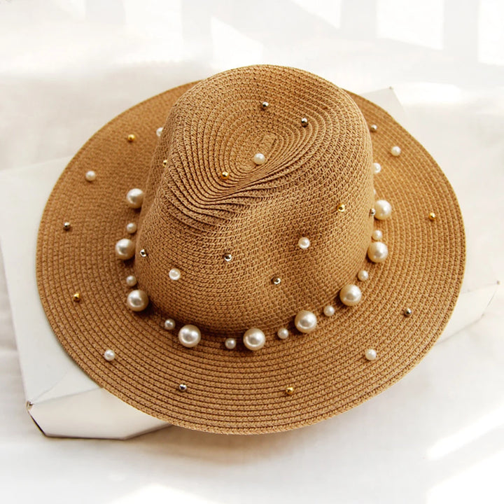 Elegant straw hat with pearl trim on display stand against neutral background