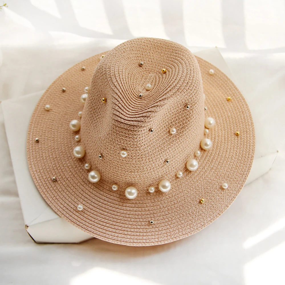 Elegant straw hat with pearl trim on display stand against neutral background