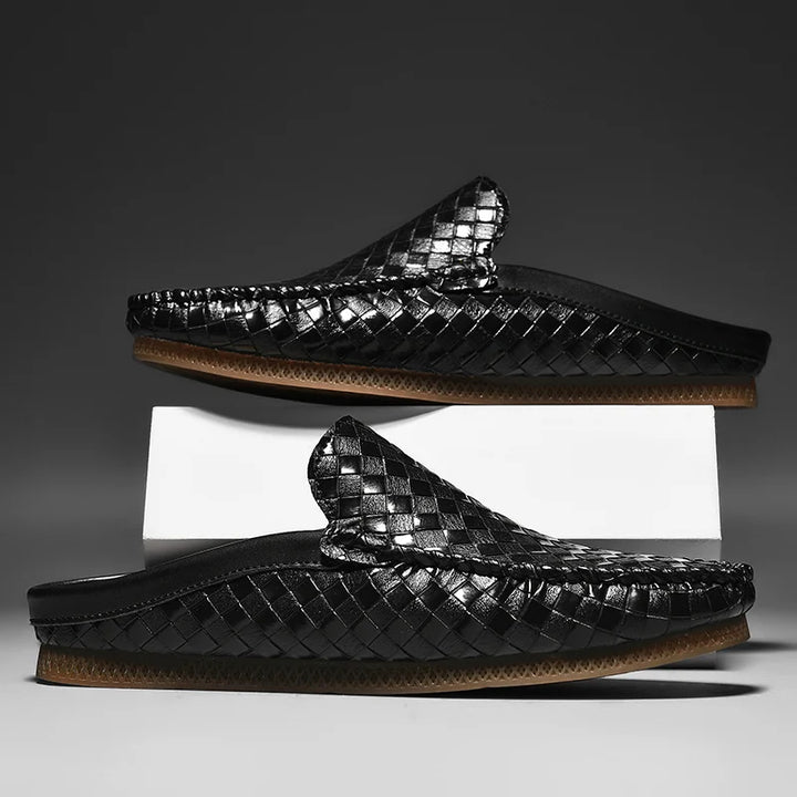 Black woven sandals on a gray background