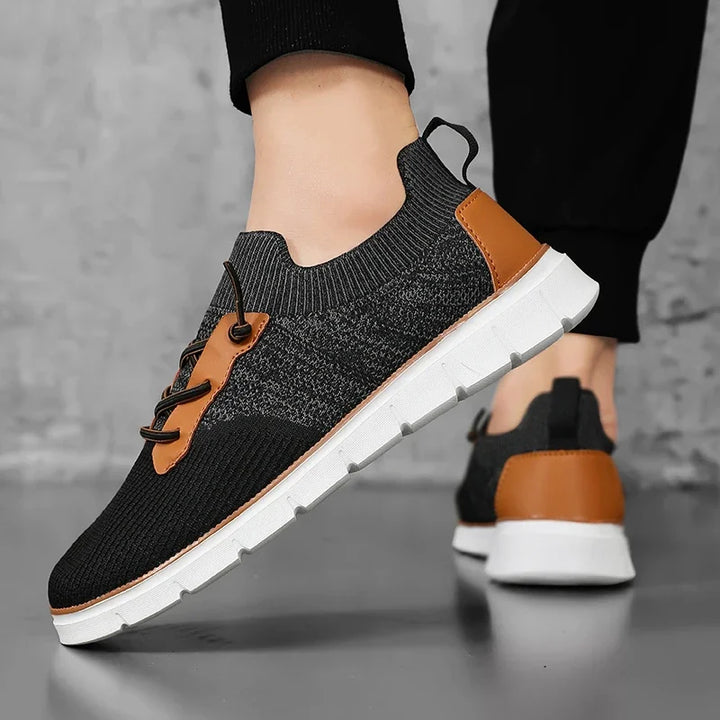 Black and brown sneakers with white soles on a gray background