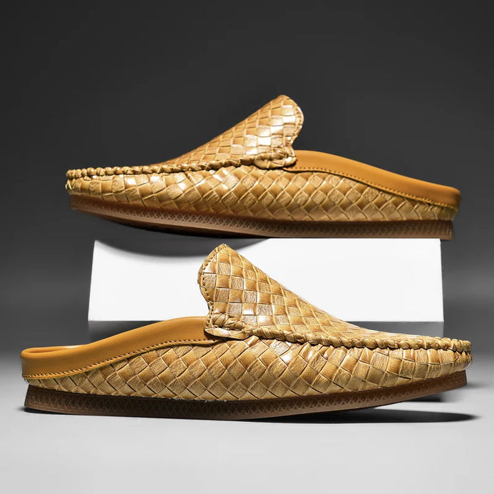 Pair of woven brown slippers on a gray background