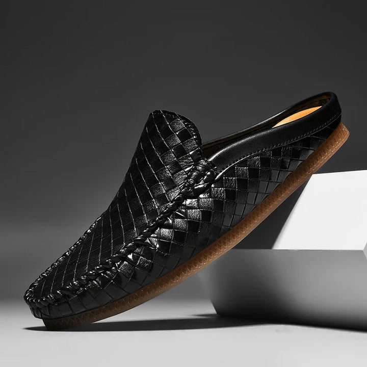 Black woven slip-on shoe on a gray background