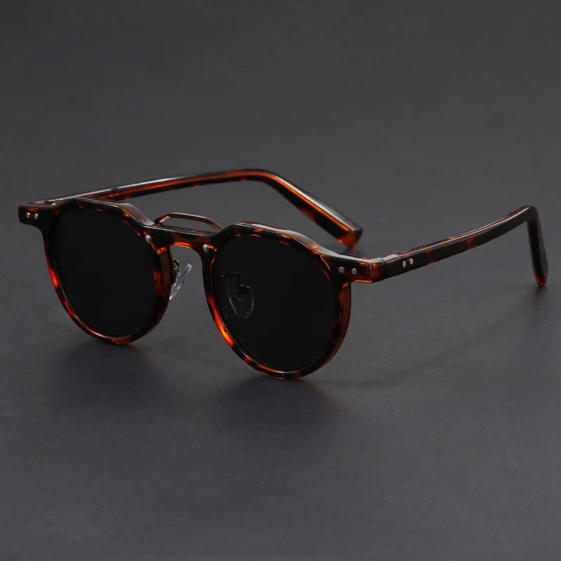 A pair of round-framed sunglasses with clear browline design and brown tortoiseshell patterned temples.