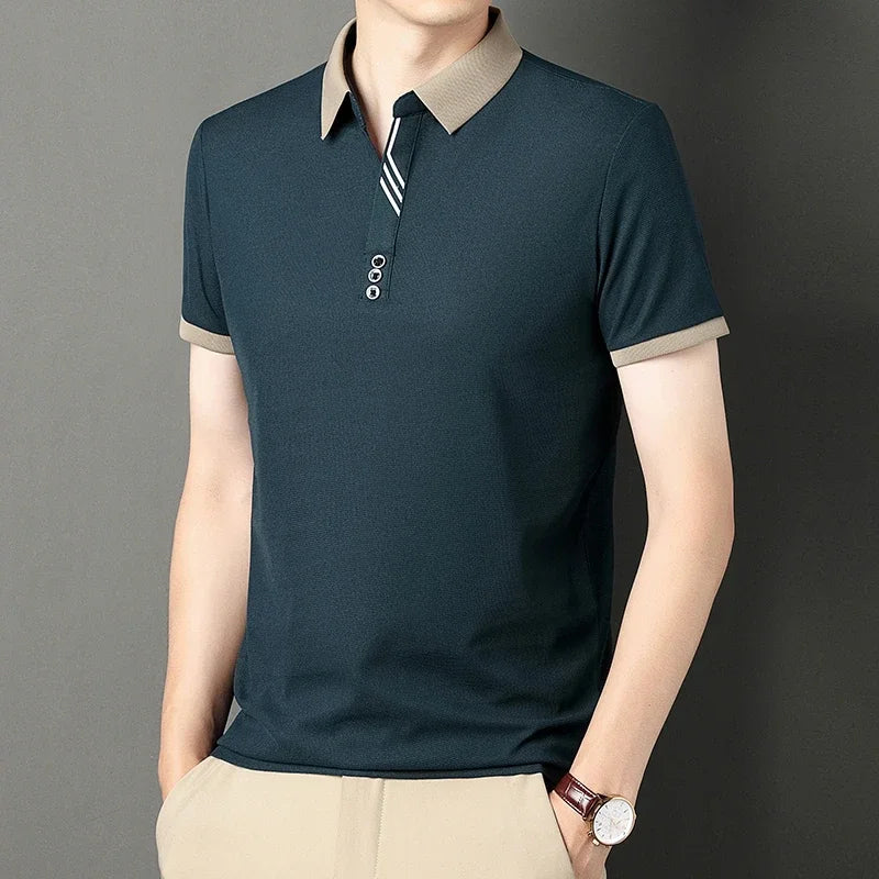 Man wearing a dark green polo shirt with beige accents on a gray background