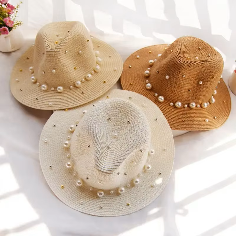 Flat lay of wide-brim straw hat with pearl accent, showing full circular shape