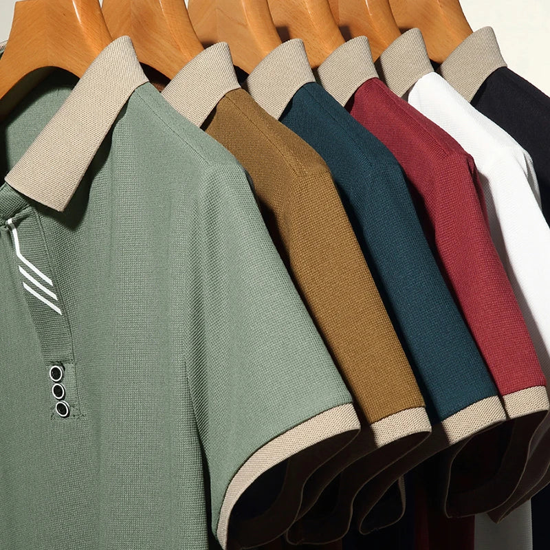 Row of polo shirts in various colors hanging on a rack.