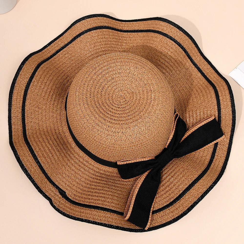 Brown straw hat with black ribbon on a beige background