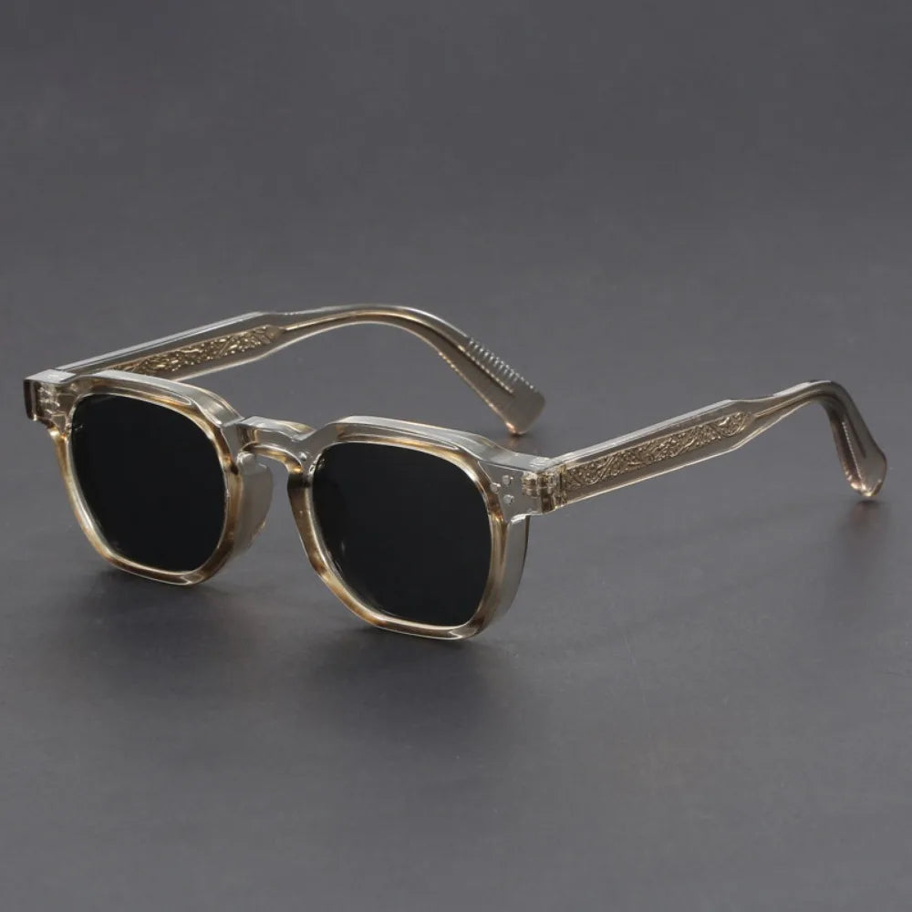 A pair of square-framed sunglasses with studded temples, featuring a patterned frame design and tinted lenses.