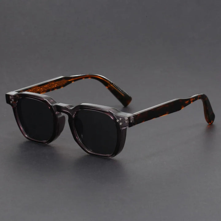 A pair of square-framed sunglasses with studded temples, featuring a patterned frame design and tinted lenses.