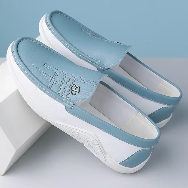 Pair of light blue and white sandals on a light gray surface with a light blue background