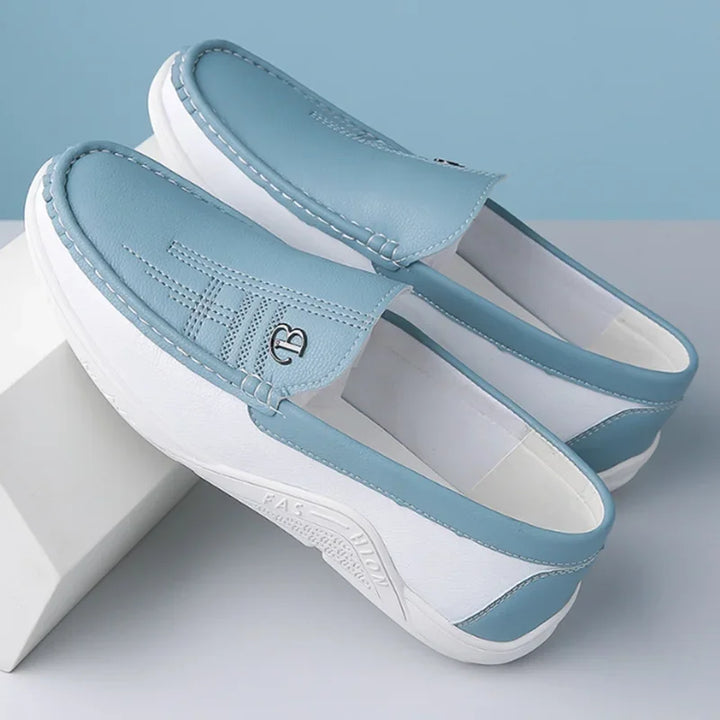 Pair of light blue and white sandals on a light gray surface with a light blue background