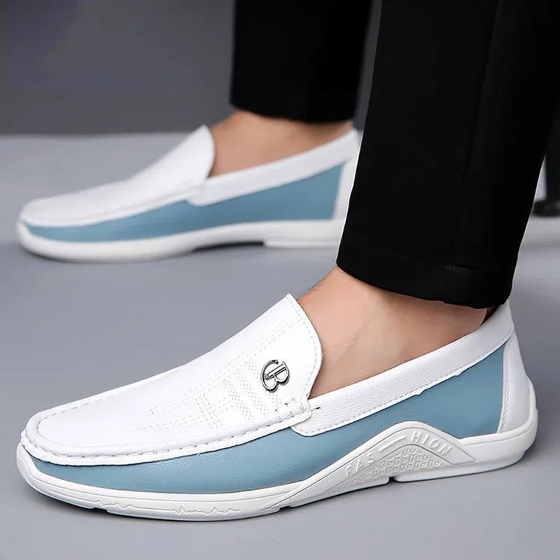 White and light blue loafers worn with black pants on a gray background